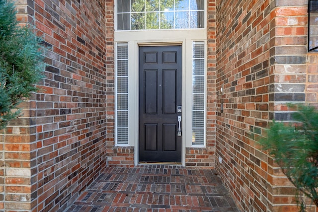 doorway to property with brick siding