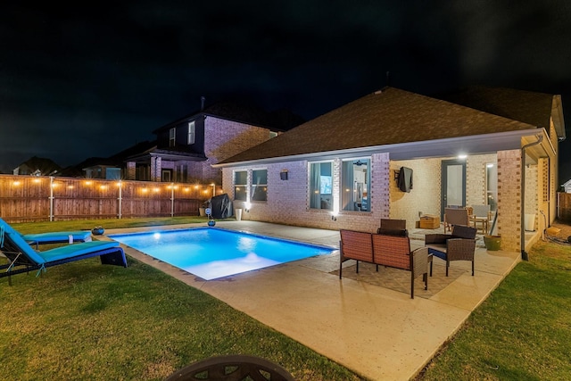 pool at twilight featuring outdoor lounge area, a yard, area for grilling, and a patio