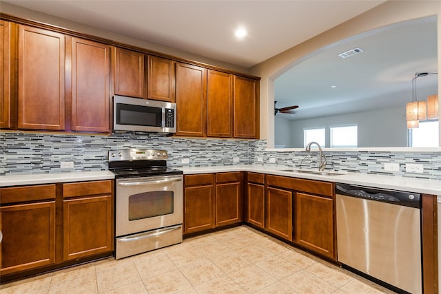 kitchen with tasteful backsplash, ceiling fan, sink, and stainless steel appliances