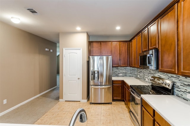 kitchen featuring tasteful backsplash, light tile patterned floors, and stainless steel appliances