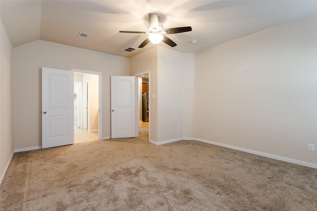 unfurnished bedroom featuring vaulted ceiling, light colored carpet, stainless steel refrigerator, and ceiling fan