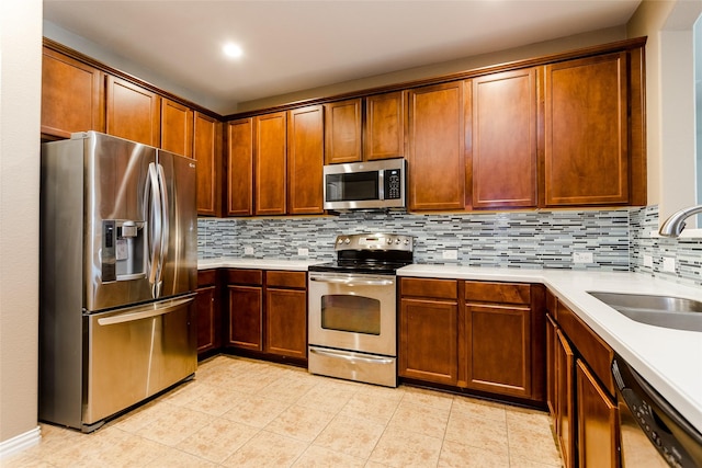 kitchen with decorative backsplash, sink, light tile patterned floors, and stainless steel appliances