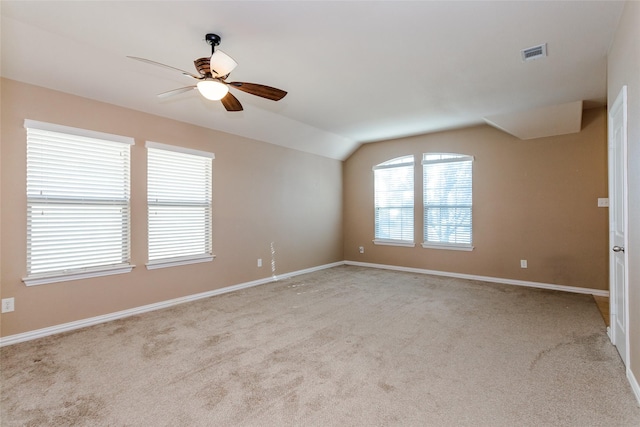 carpeted spare room with ceiling fan and vaulted ceiling