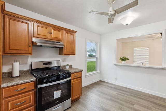 kitchen with ceiling fan, stainless steel range with gas cooktop, and light wood-type flooring