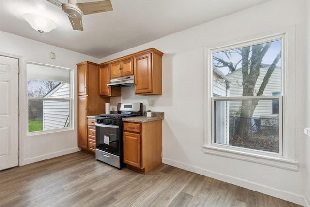 kitchen with ceiling fan, stainless steel range with gas stovetop, and light hardwood / wood-style floors