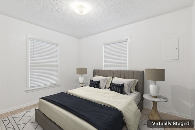 carpeted bedroom featuring electric panel and a textured ceiling