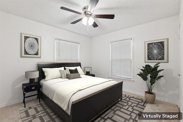 bedroom with ceiling fan, carpet flooring, and a textured ceiling