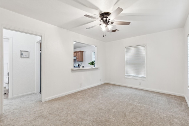 unfurnished room with light colored carpet and ceiling fan