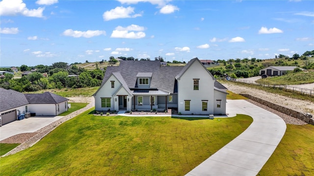 view of front of house featuring a garage, a porch, and a front lawn