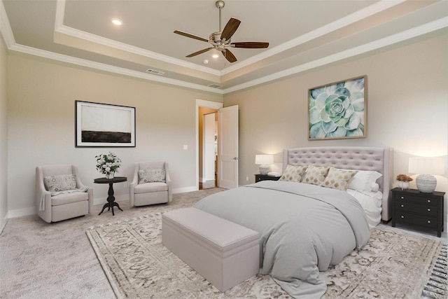 carpeted bedroom with ornamental molding, ceiling fan, and a tray ceiling