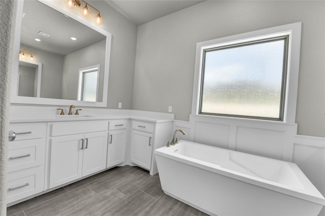 bathroom with a washtub and vanity