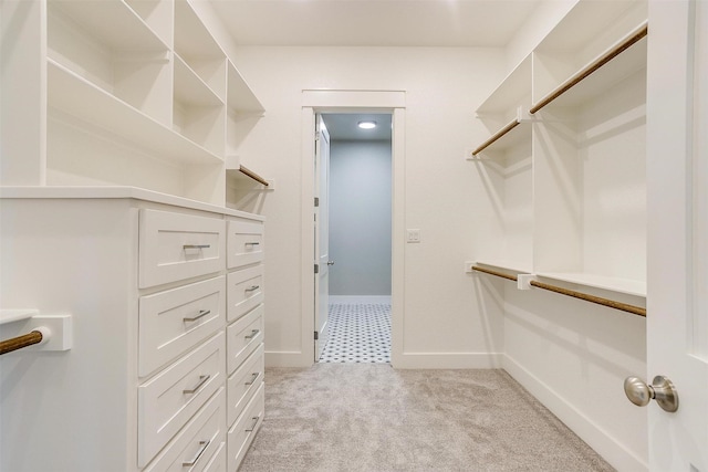 walk in closet featuring light colored carpet