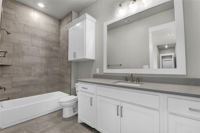 full bathroom featuring vanity, tiled shower / bath combo, and toilet