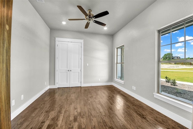 interior space featuring dark wood-type flooring, ceiling fan, and a closet