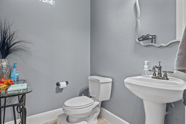 bathroom with tile patterned flooring, toilet, and sink