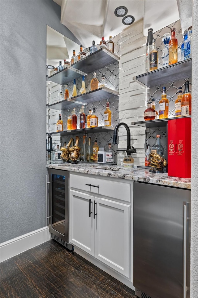 bar with white cabinetry, light stone countertops, tasteful backsplash, wine cooler, and dark hardwood / wood-style flooring