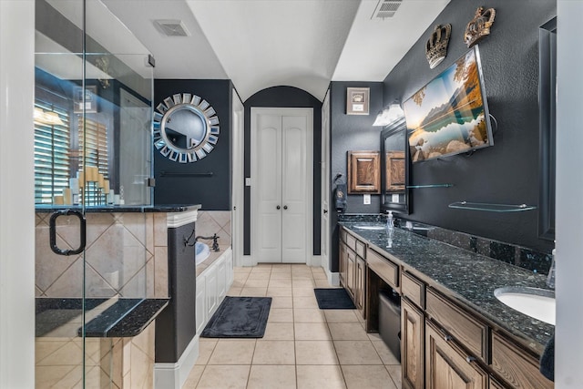 bathroom with tile patterned flooring, vanity, and plus walk in shower