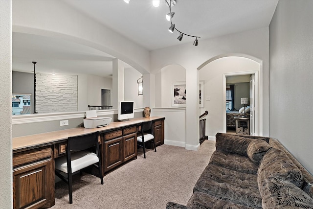 home office with light colored carpet and built in desk