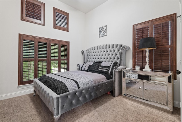 carpeted bedroom featuring a high ceiling