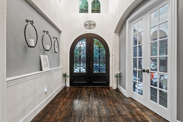 entryway with french doors, dark hardwood / wood-style floors, and a high ceiling