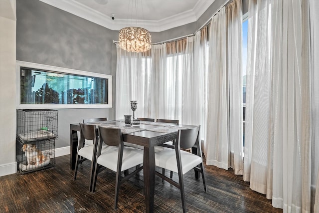 dining space featuring ornamental molding, dark wood-type flooring, and an inviting chandelier