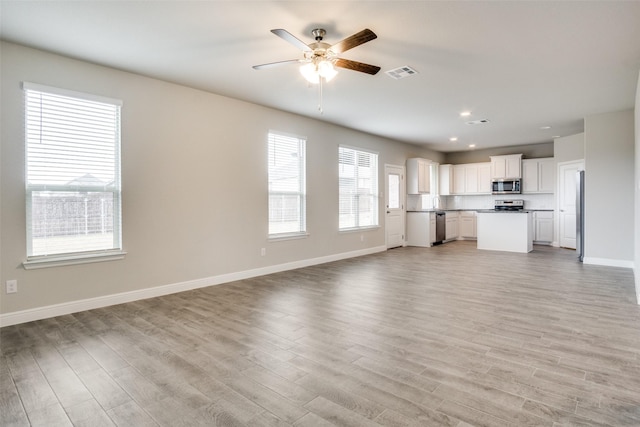 unfurnished living room with light hardwood / wood-style floors and ceiling fan