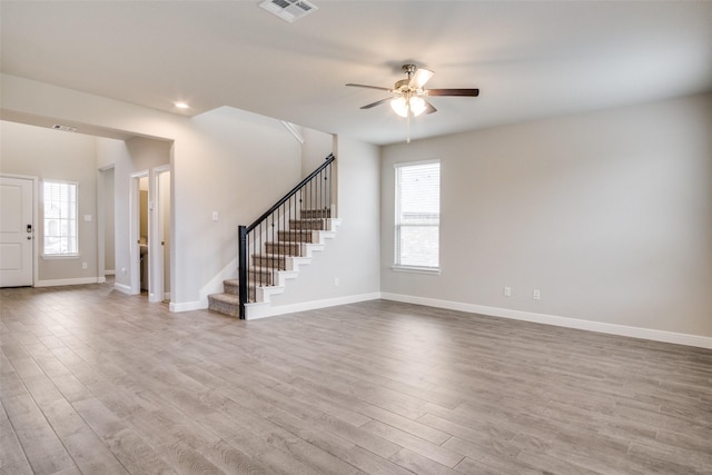 unfurnished living room featuring ceiling fan, a healthy amount of sunlight, and light wood-type flooring