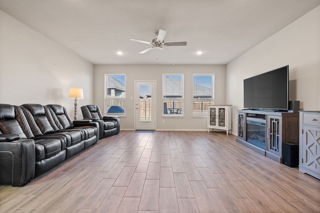 living room featuring a wealth of natural light, light hardwood / wood-style flooring, and ceiling fan