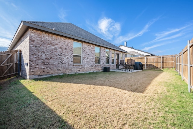 rear view of property with a yard and a patio area