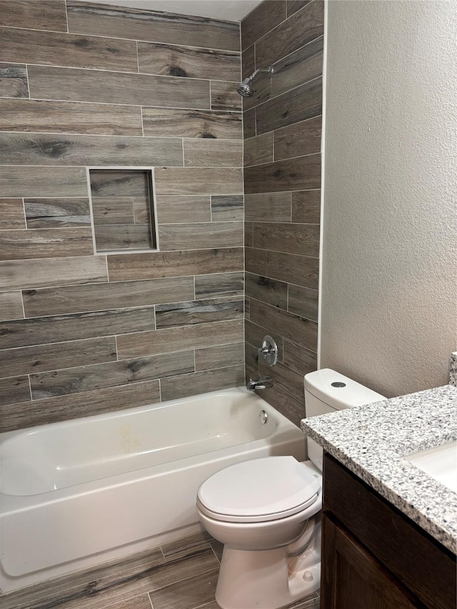 full bathroom with toilet, tiled shower / bath combo, and vanity