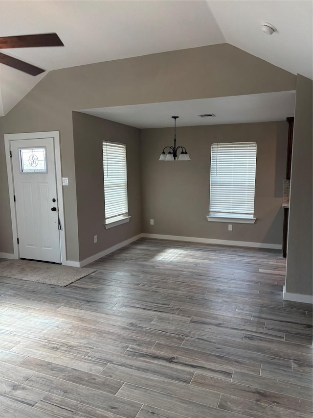 foyer featuring a wealth of natural light, lofted ceiling, and ceiling fan with notable chandelier