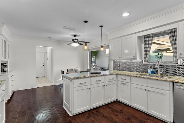 kitchen with white cabinetry, sink, stainless steel dishwasher, and kitchen peninsula