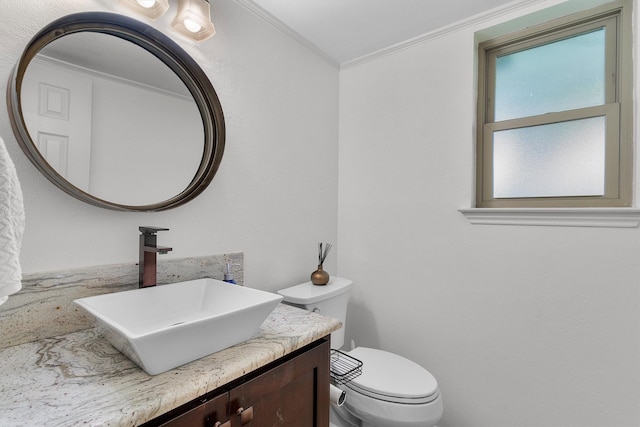 bathroom with vanity, ornamental molding, and toilet