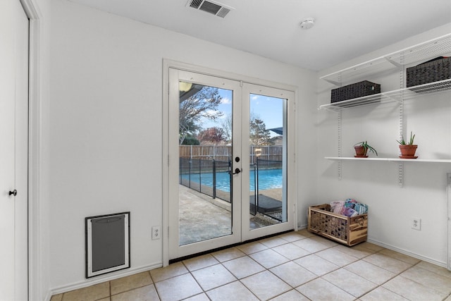 doorway with light tile patterned flooring and french doors