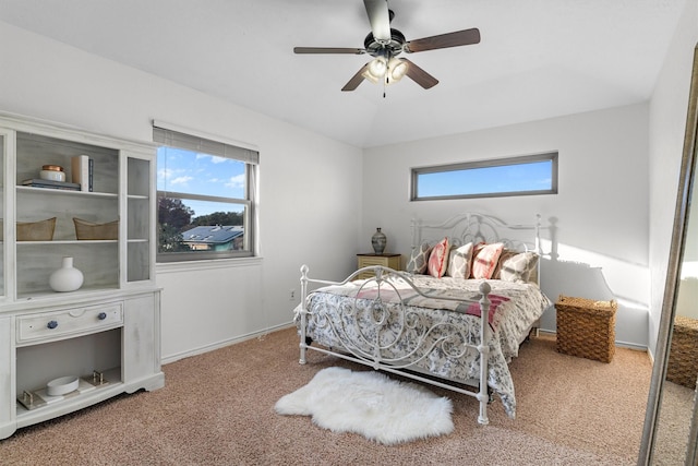 carpeted bedroom with ceiling fan, lofted ceiling, and multiple windows