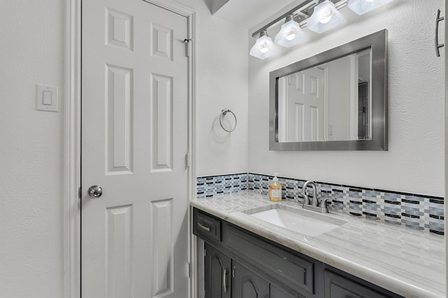 bathroom featuring vanity and backsplash