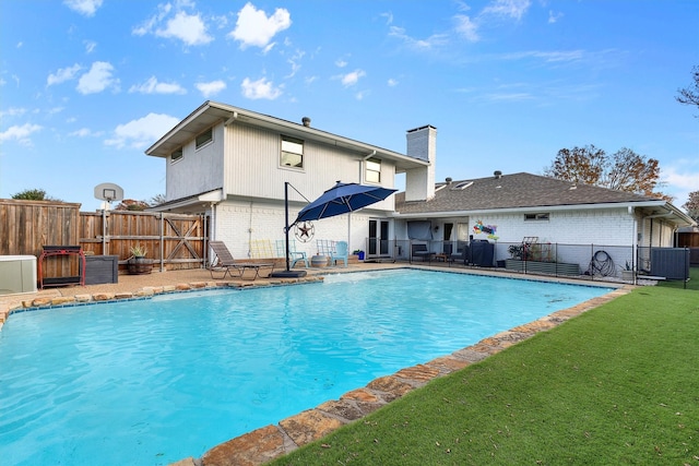 view of pool featuring a yard and central AC unit