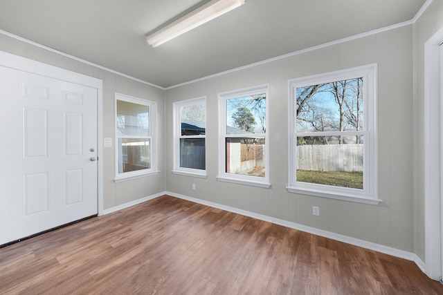 interior space featuring wood-type flooring, crown molding, and a wealth of natural light