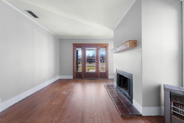 unfurnished living room with dark wood-type flooring, ornamental molding, and vaulted ceiling