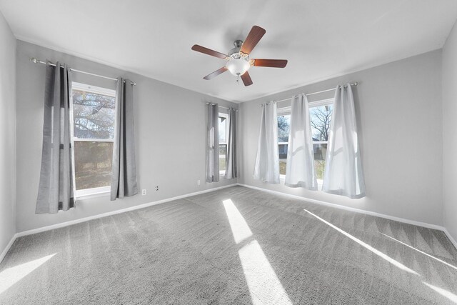 carpeted spare room with ceiling fan