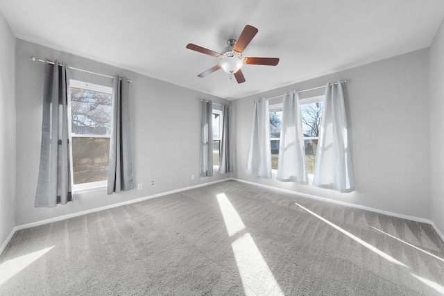 empty room featuring a healthy amount of sunlight, carpet floors, and ceiling fan