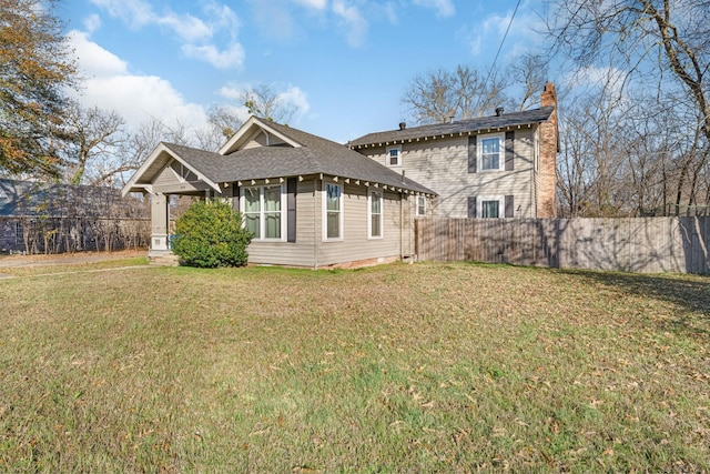 rear view of house featuring a yard