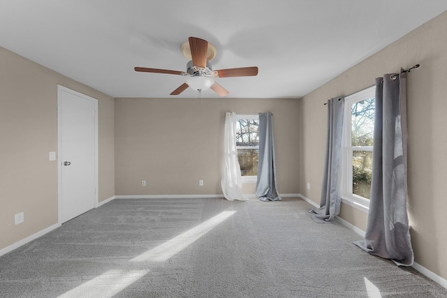 carpeted empty room with ceiling fan and a healthy amount of sunlight