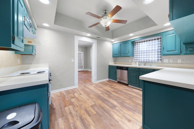 kitchen featuring light wood-type flooring, stainless steel dishwasher, a raised ceiling, ceiling fan, and blue cabinetry