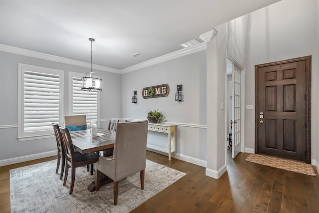 dining room with ornamental molding, dark hardwood / wood-style floors, and a chandelier