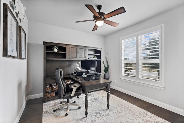 home office with dark hardwood / wood-style flooring and ceiling fan