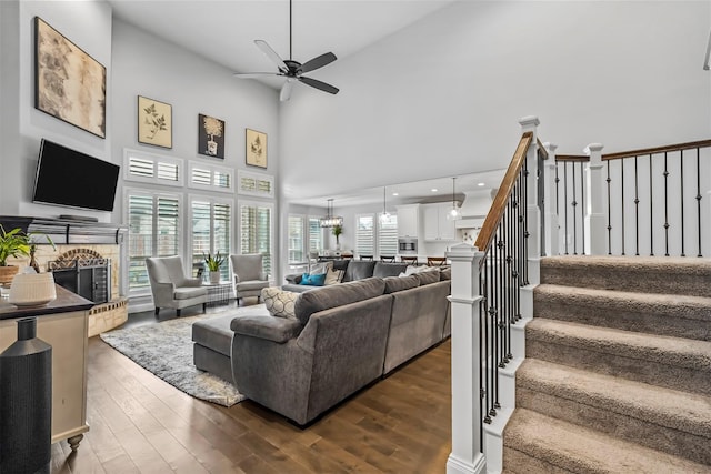 living room featuring ceiling fan, dark hardwood / wood-style flooring, and a high ceiling