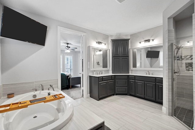 bathroom featuring independent shower and bath, vanity, and ceiling fan