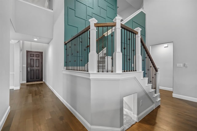 stairs with hardwood / wood-style flooring and a high ceiling