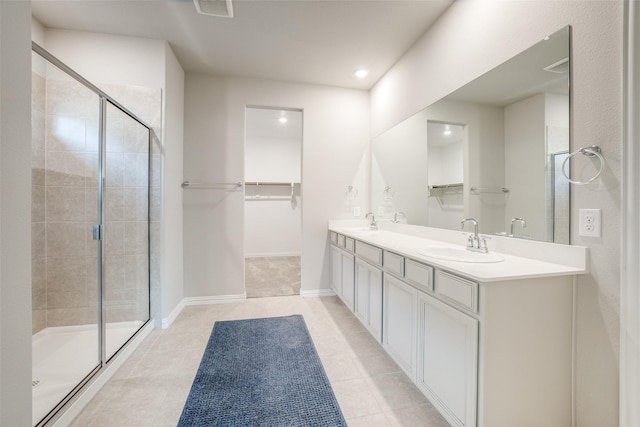 bathroom featuring a shower with door, vanity, and tile patterned flooring